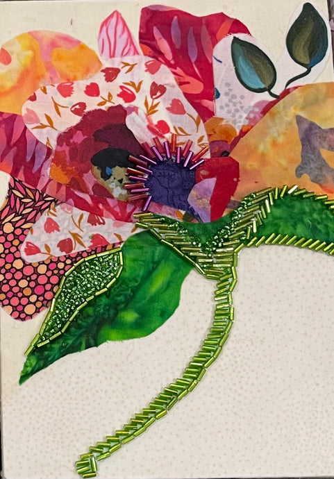 Botanical fabric mixed media wall art with colorful flower, green beaded stem, and layered textile petals