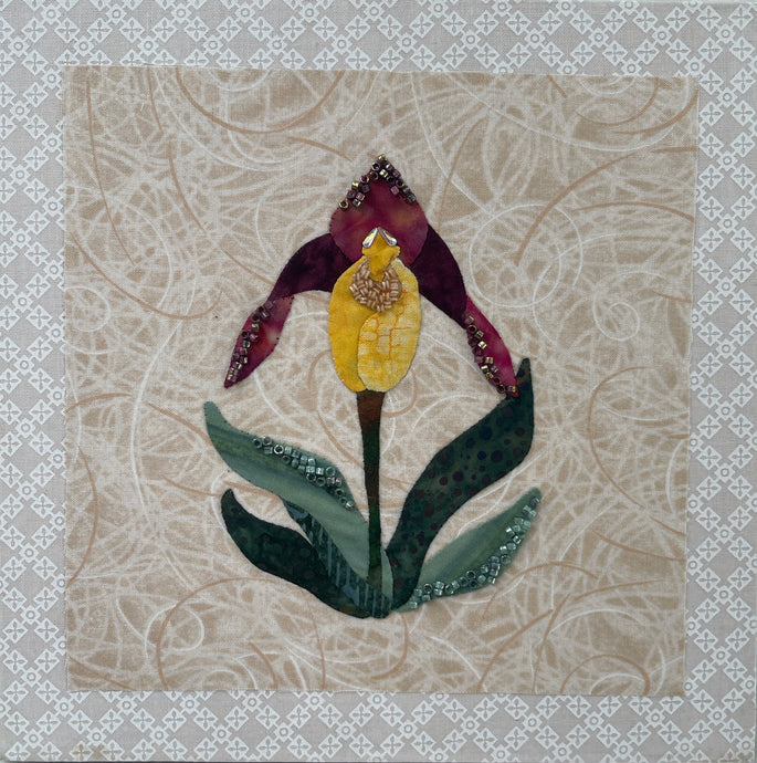 8 x 8 fabric collage artwork featuring a single yellow and burgundy flower made from inherited textiles with bead embellishments on neutral background