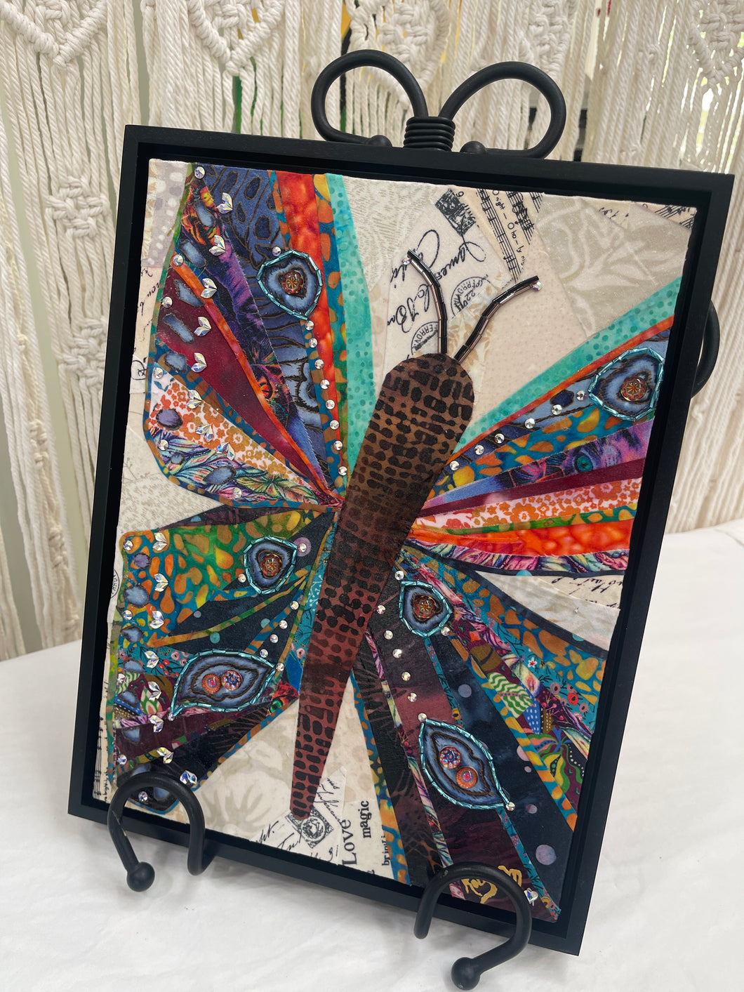 Original butterfly fabric collage artwork 9x12 inches, fanned patchwork wings in teal, orange, purple, and red, beaded eye-spot accents, Swarovski crystals, vintage paper background, birch panel, Floral and Botanical Collection, Robyn Moore Arts