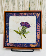 8 x 8 fabric collage artwork featuring a purple thistle flower with bead embellishments made from inherited textiles on neutral background
