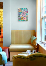 Original mixed media botanical painting Where the Garden Sings by Robyn Moore Arts displayed above a gold velvet banquette in an eclectic sitting room with jewel toned furniture and natural window light