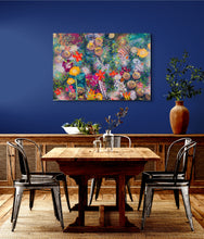 Original large botanical acrylic painting Where the Garden Overflows by Robyn Moore Arts displayed above a dining table on a wide horizontal wall in a warm richly decorated interior