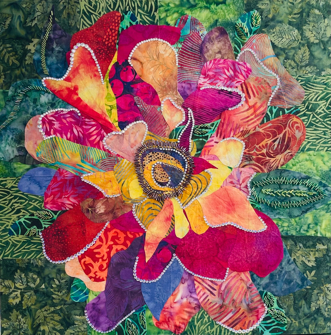 Original mixed media botanical artwork 20x20 inches, oversized flower constructed from layered batik fabrics in crimson magenta orange gold and violet, crystal outlined petals, Czech glass bead center detail, lush green foliage background, on birch panel, part of the Floral and Botanical Collection by Robyn Moore Arts