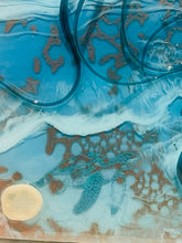 close-up of shimmery turtle and sand dollar with wave details